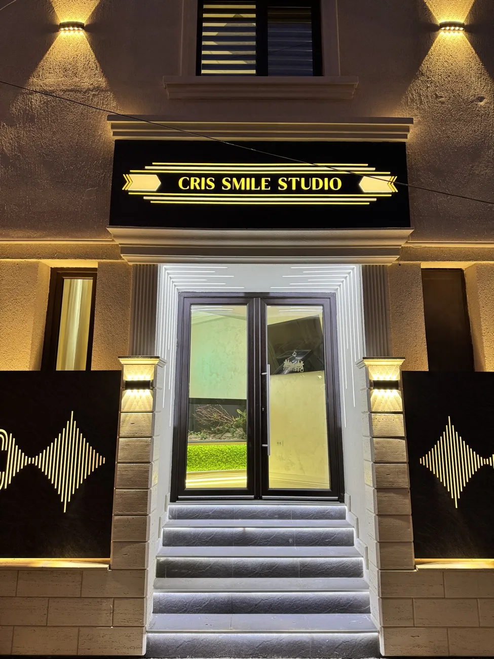 Intrarea în clinica Cris Smile Studio București, iluminată seara